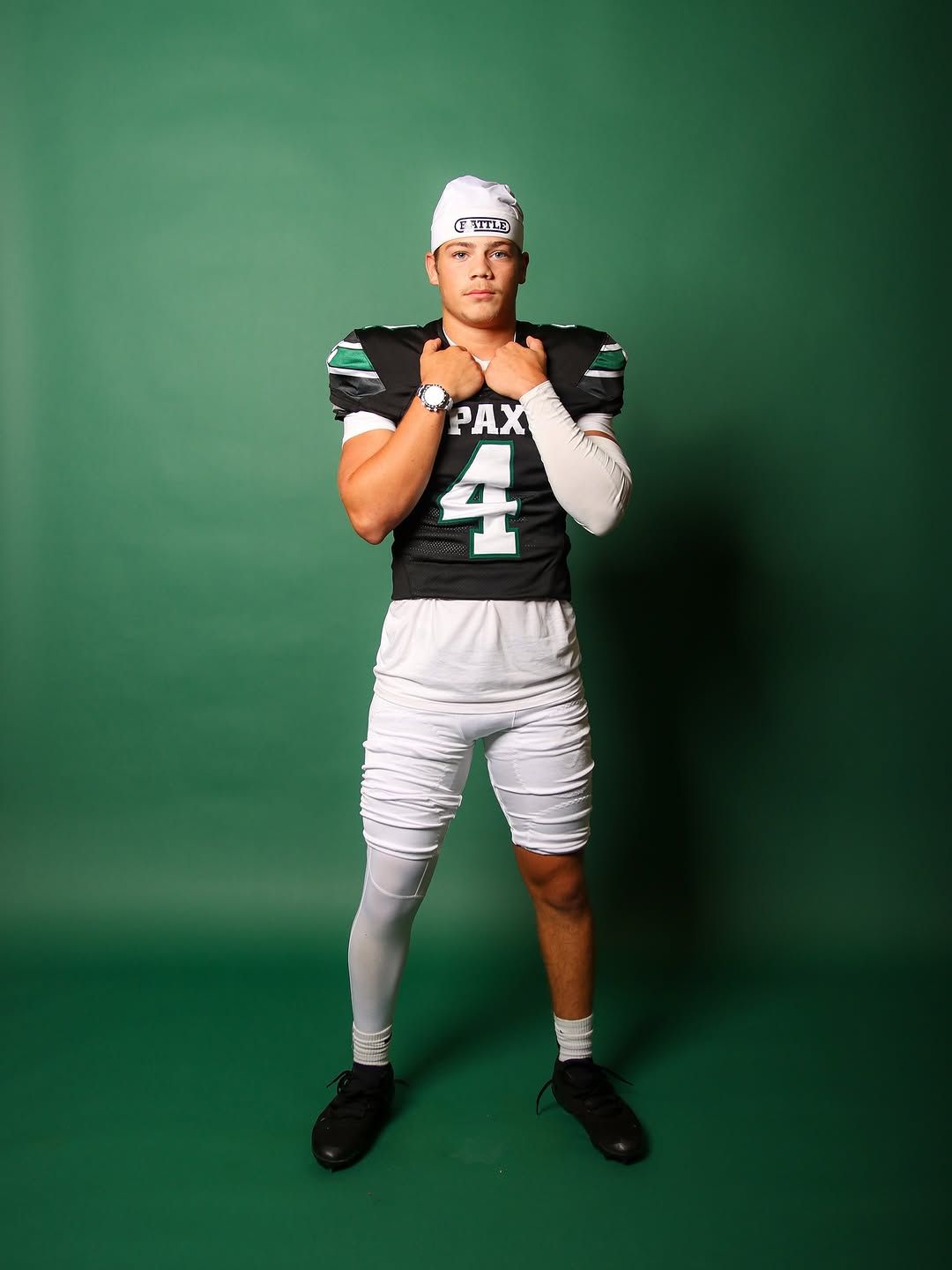 Football player in a PAX #4 jersey on a green backdrop